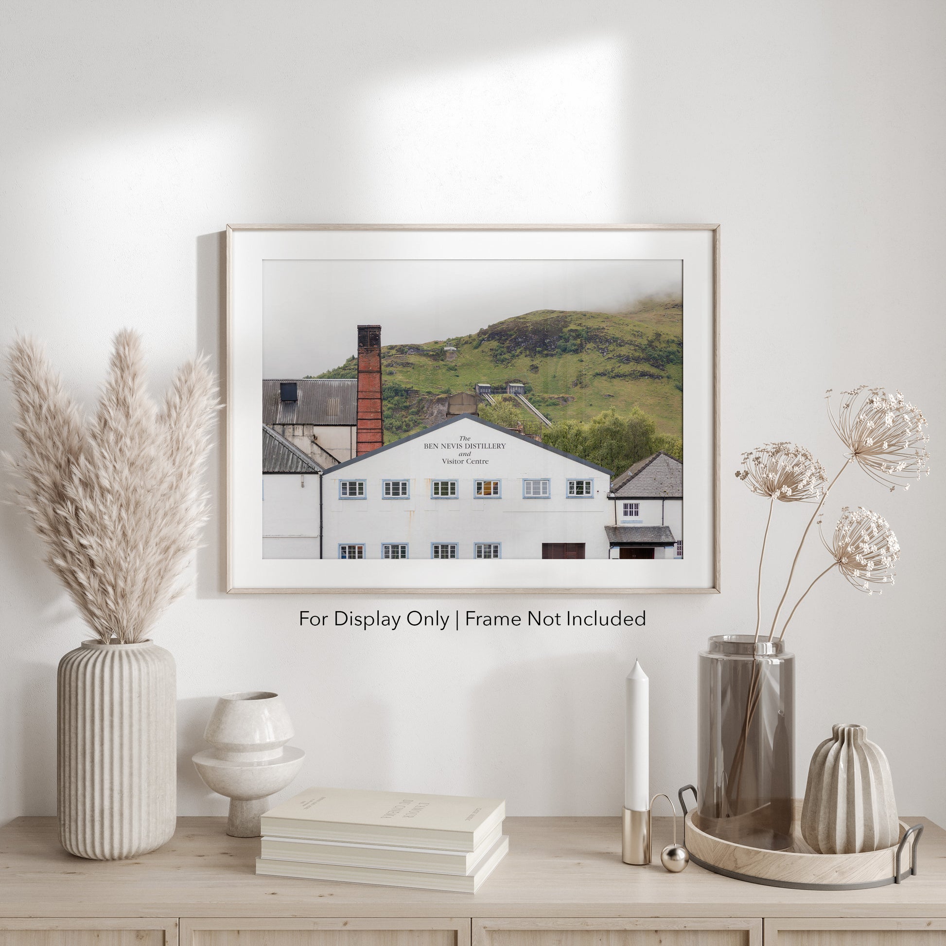 Ben Nevis Distillery and Visitor Centre in Fort William, Scotland, with whitewashed walls, red brick chimney, and Highland hills in the background.