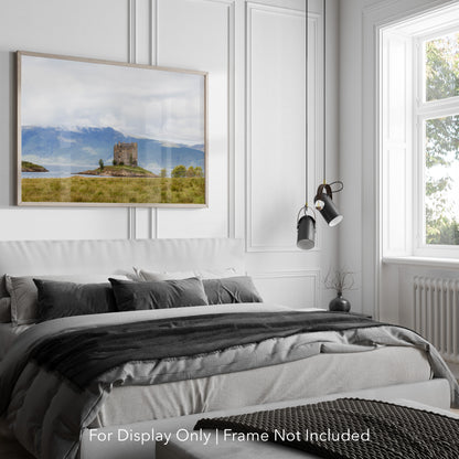 Castle Stalker on a small island in Loch Laich, Scottish Highlands, surrounded by mountains and water.