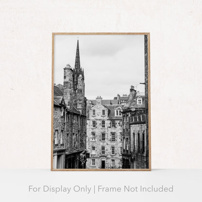 Black and white photograph of an Edinburgh street with historic stone architecture and a church spire.