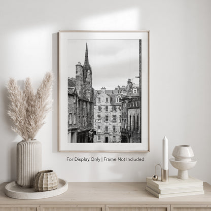 Black and white photograph of an Edinburgh street with historic stone architecture and a church spire.