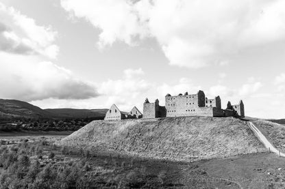 Black-and-white photograph of Ruthven Barracks ruins in the Scottish Highlands, set on a grassy hill with dramatic skies.