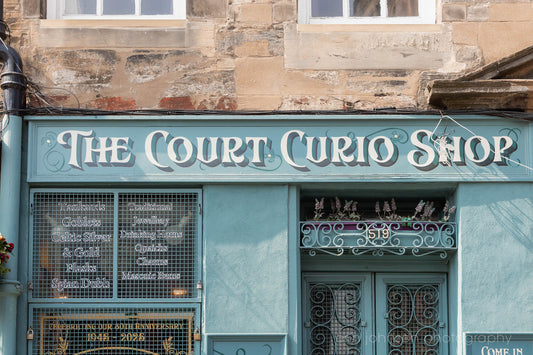 The Court Curio Shop in Edinburgh, Scotland, with teal storefront, ornate lettering, and historic stone facade.