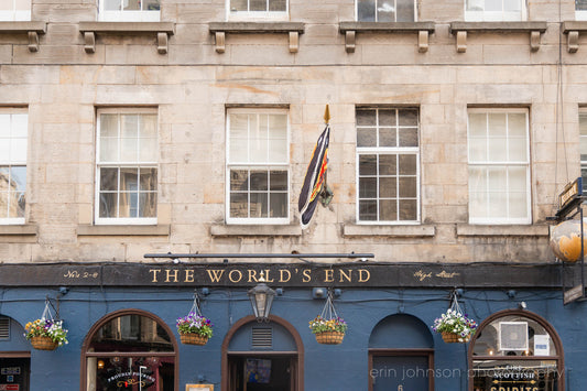 The World’s End pub on Edinburgh’s Royal Mile with blue facade, hanging flowers, and historic gold signage.