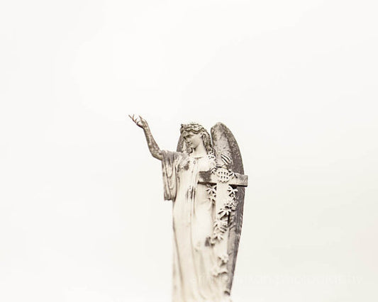 a statue of an angel holding a cross