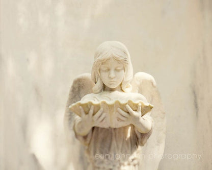 a statue of an angel holding a shell
