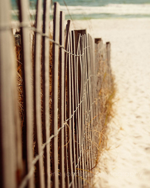 a beach with a fence and a surfboard on it