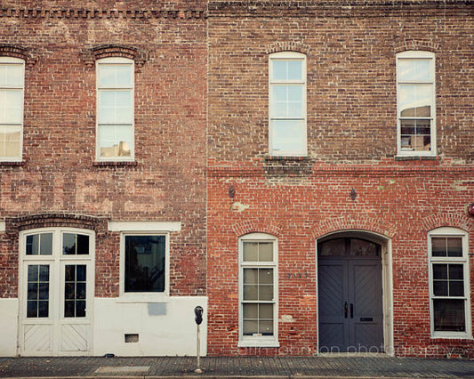 a red brick building with three windows and a white door