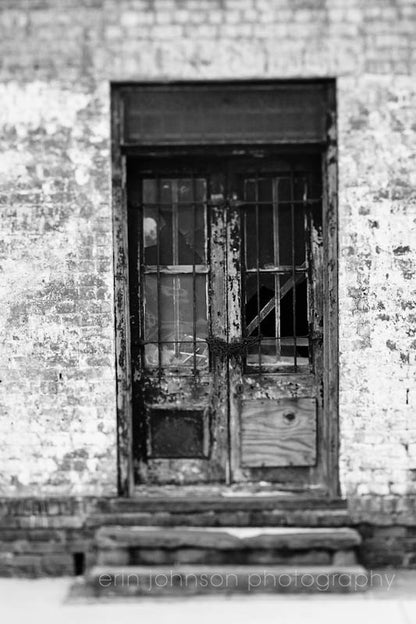 a black and white photo of a door and window