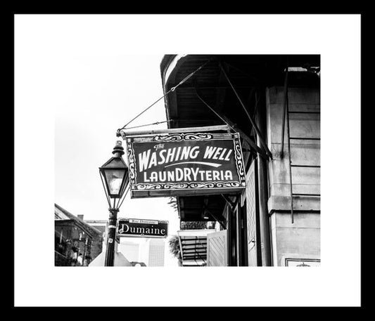 a black and white photo of a sign for washing well laundryteria