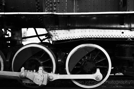 a black and white photo of the wheels of a train