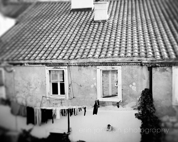 a black and white photo of a house with clothes hanging out to dry