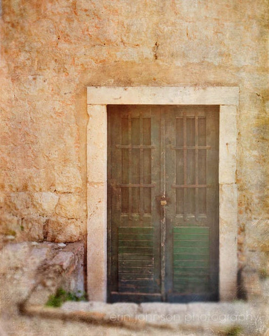 an old door with bars on the side of a building