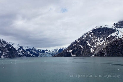 a large body of water surrounded by snow covered mountains