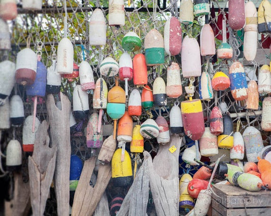 a bunch of buoys hanging from a wire fence