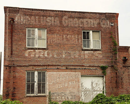 A photograph featuring a brick building with 'Andalusia Grocery Co' signage, indicating a vintage or historical building in Andalusia, Alabama.
