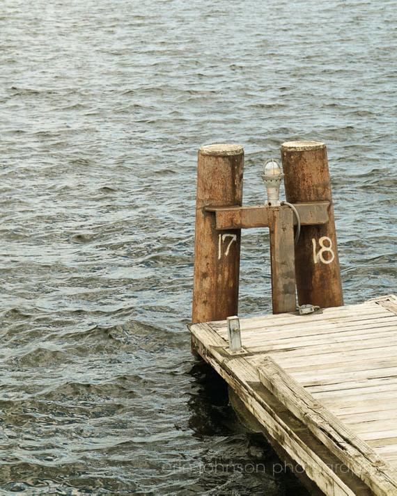 a wooden dock with two wooden poles sticking out of the water