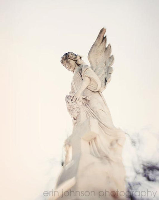 a statue of an angel holding a bouquet of flowers