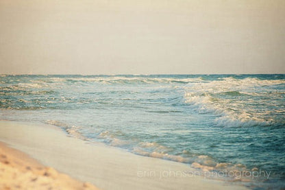a sandy beach with waves coming in to shore