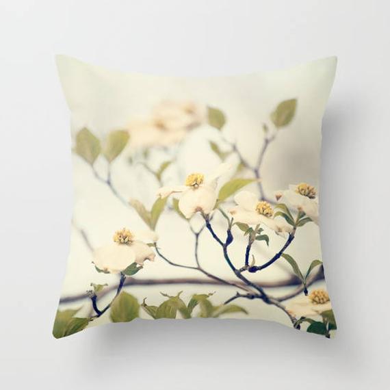 a pillow with white flowers on a white background
