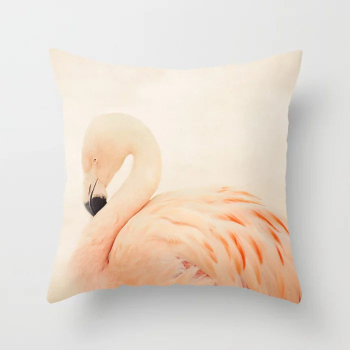a pink flamingo sitting on top of a white pillow