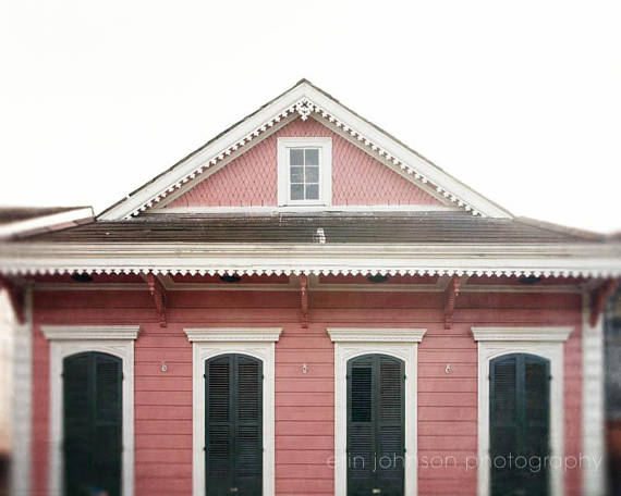 a pink house with black shutters and a white roof