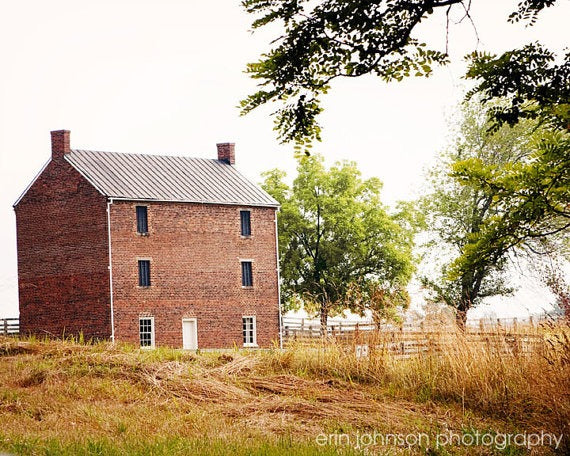 a red brick building sitting on top of a lush green field