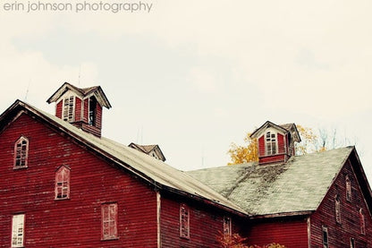 a red barn with two windows and a steeple