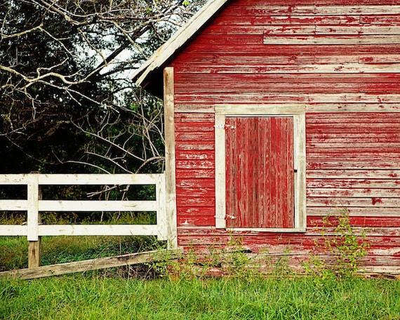 a red barn with a white fence and a red door