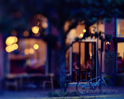 A nighttime photograph of a cafe with lit streetlights and a tree in front, part of a series on Savannah, Georgia, photography.