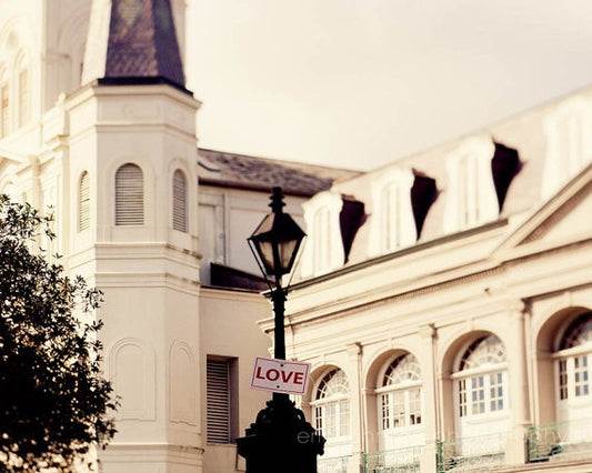 a white building with a clock tower and a love sign in front of it