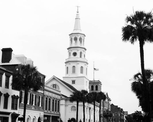 a black and white photo of a church and palm trees