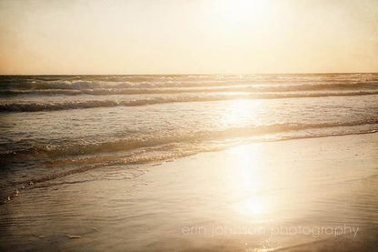 the sun is shining over the water at the beach