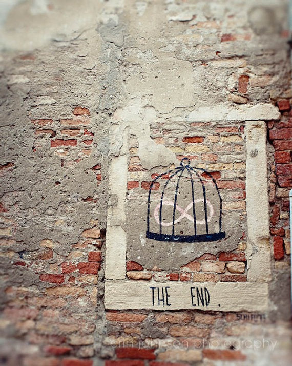 a brick wall with a birdcage painted on it