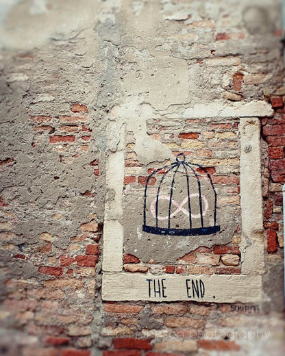 Graffiti artwork reading “The End” on a weathered brick wall in Venice, Italy – fine art travel photography print for wall art decor.