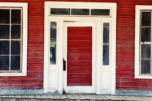 a red building with two white doors and windows