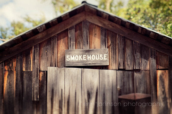 a smokehouse with a sign on the side of it