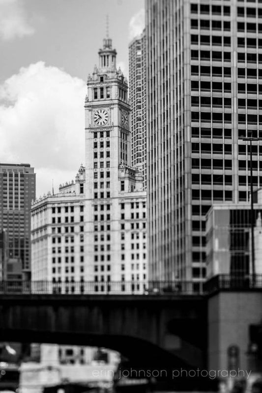 a black and white photo of a clock tower in a city
