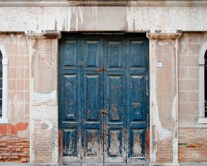 an old building with two blue doors and windows