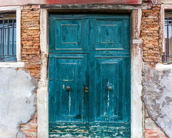 an old building with a green door and windows