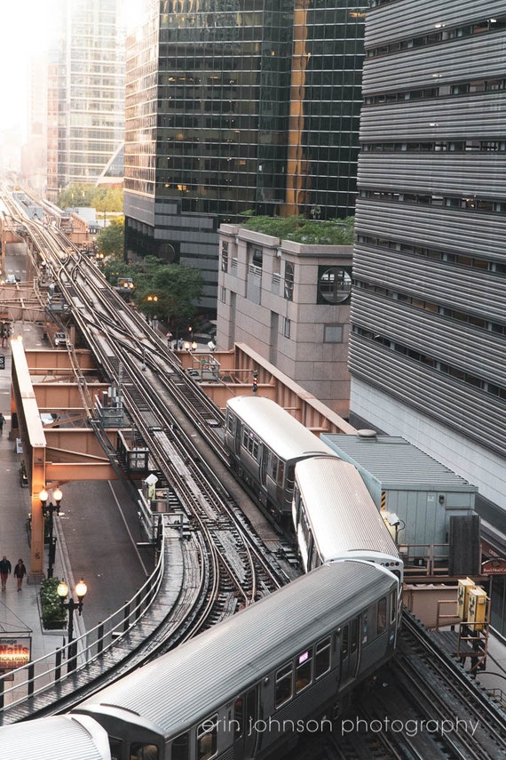 a train traveling through a train station next to tall buildings