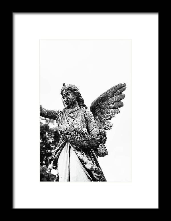 a black and white photo of a statue of an angel