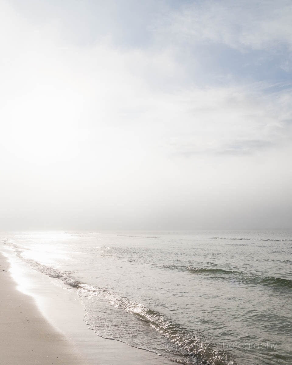 a sandy beach with waves coming in to the shore