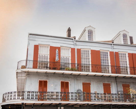 a tall building with red shutters and balconies