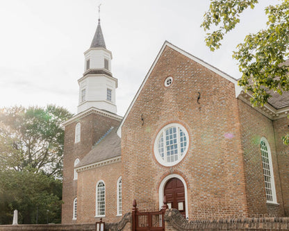 an old brick church with a steeple and a gate