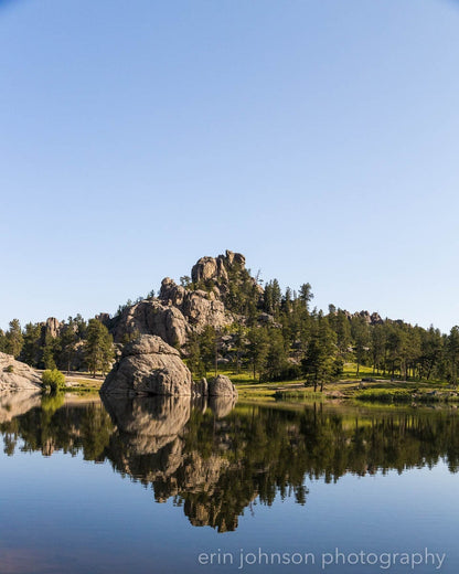 a lake surrounded by large rocks and trees