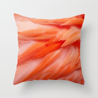 an orange pillow with feathers on it