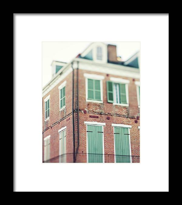 an old brick building with green shutters and windows