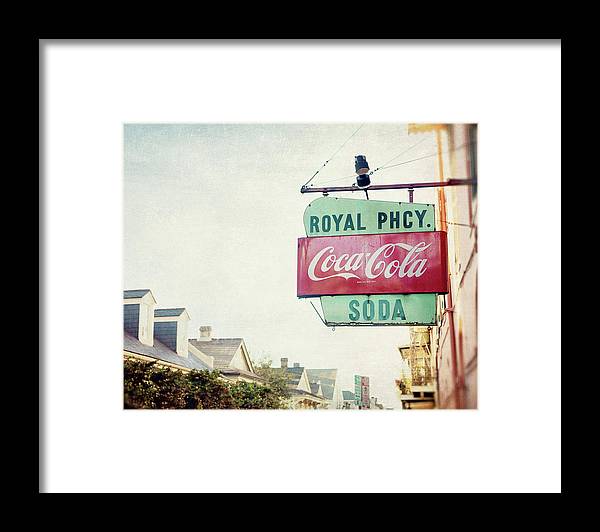 a coca cola sign hanging from the side of a building