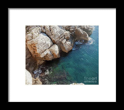 an aerial view of a rocky coastline with blue water