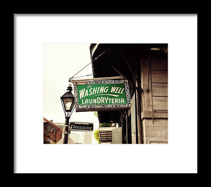 a green and white sign hanging from the side of a building